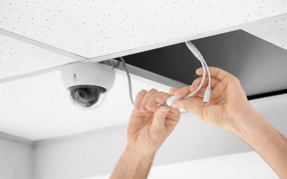 Installation d'une caméra de surveillance dôme au plafond par un technicien