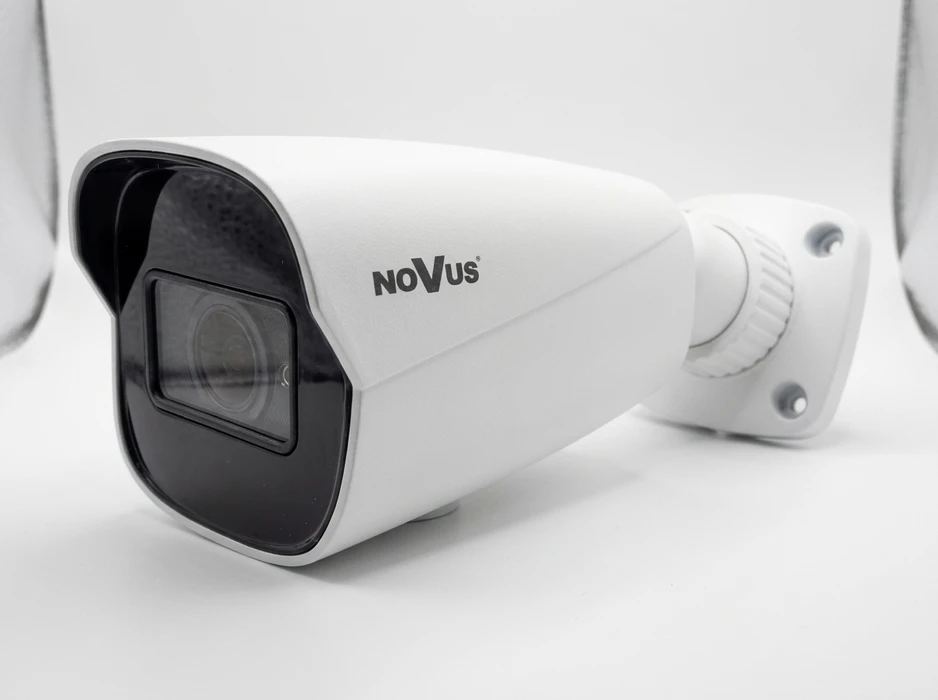 Caméra de surveillance moderne montée à l'extérieur contre un ciel bleu nuageux